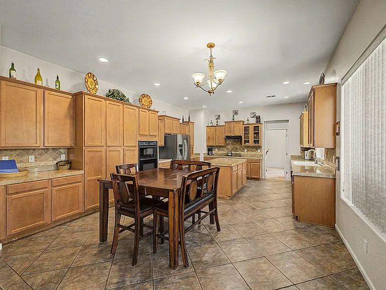Spacious eat-in kitchen with abundant cabinetry, center island, and large window over the sink for everyday convenience.