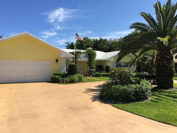 Partial view of house front, circular drive, and garage.