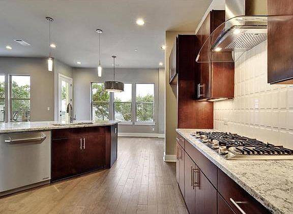 Wood floors, slab granite counters, Dacor appliances, Timberland cabinetry, designer pendant and din