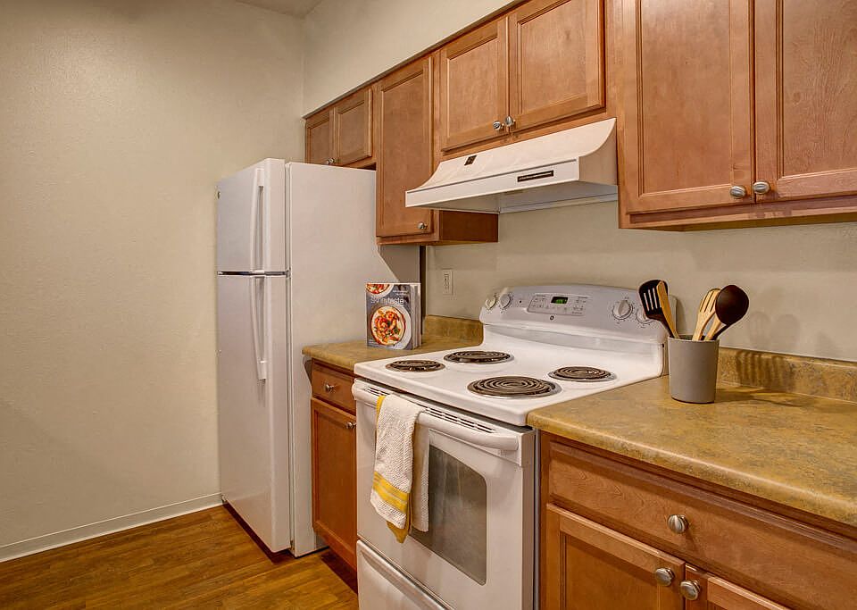Oven, stove, and refrigerator surounded by beautiful cabinetry