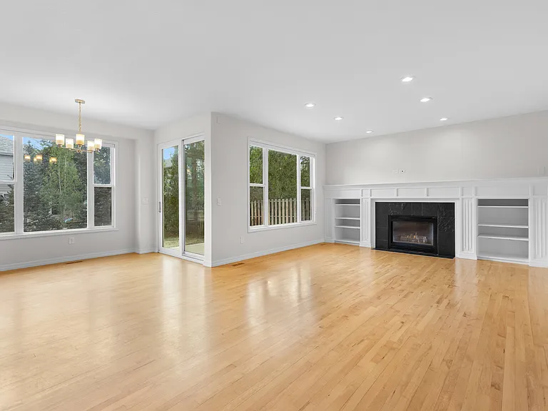 The open-concept main living area features a spacious living room and dining nook with hardwood floors, abundant natural light, and a cozy gas fireplace.
