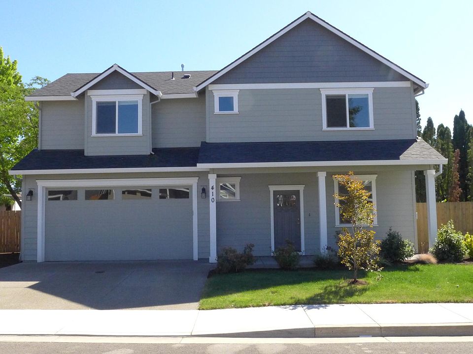 Front of house showing driveway, lawn (automatic sprinklers) and garage.