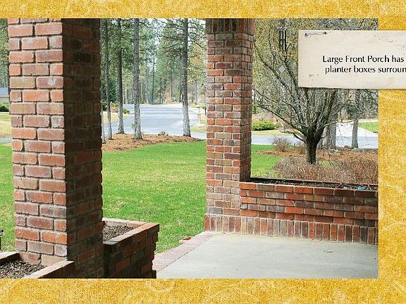 Brick columns and planters surround large porch entry