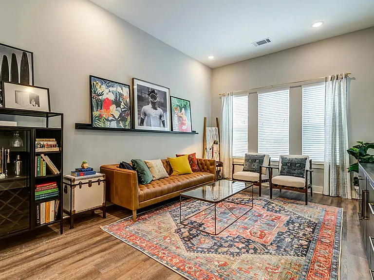 Spacious Living Area with Eclectic Decor, Natural Light, and Wood-Style Flooring