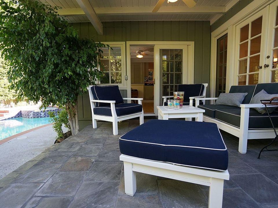 Covered patio provides outdoor living space off the sunroom/livingroom next to the pool