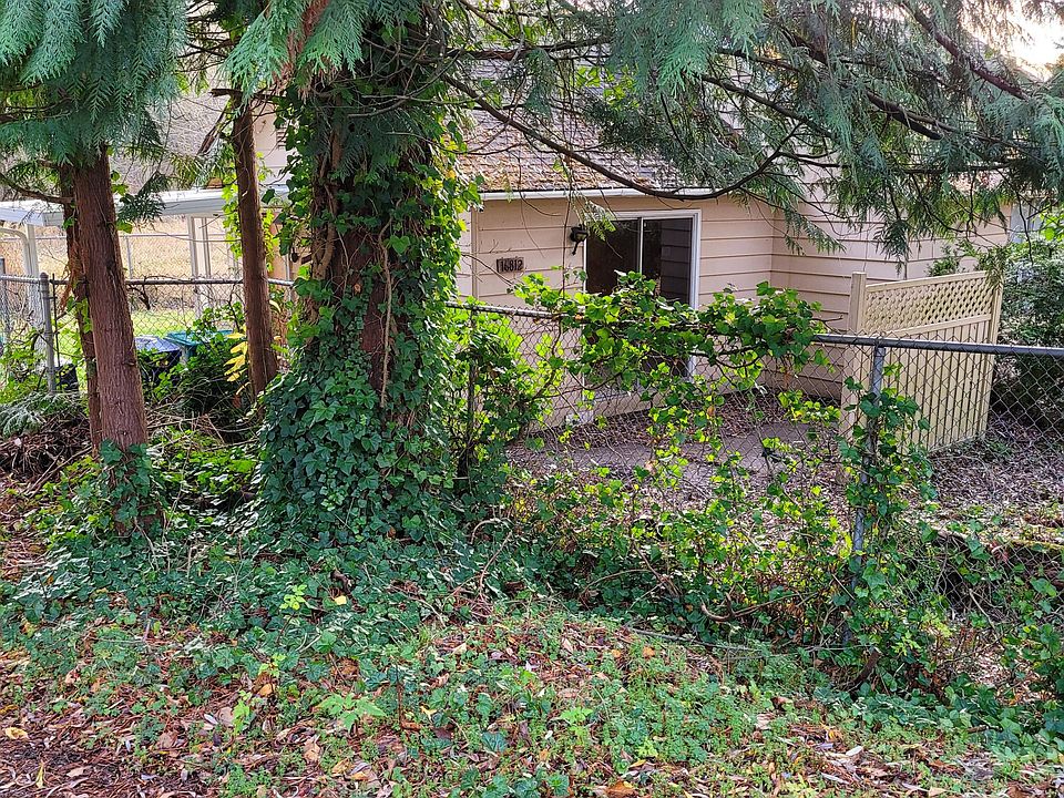 Partial view of the homes patio area with sliding door leading out. Tall cyclone fencing surrounding yard and home and connecting to the attached garage for security. Home also has an alarm system and also a ring flood cam video camera over garage and l