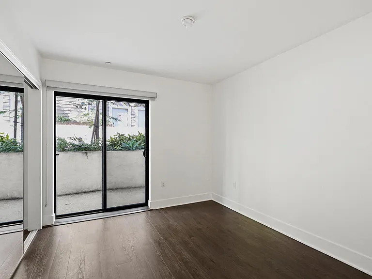Bedroom with Mirrored Closet, Vinyl Flooring, and Patio