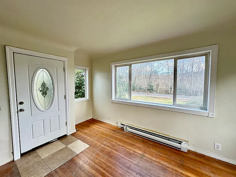 Very large light and bright living room with new heaters and a cozy pellet stove for additional heat. Hardwood floor will be refinished.