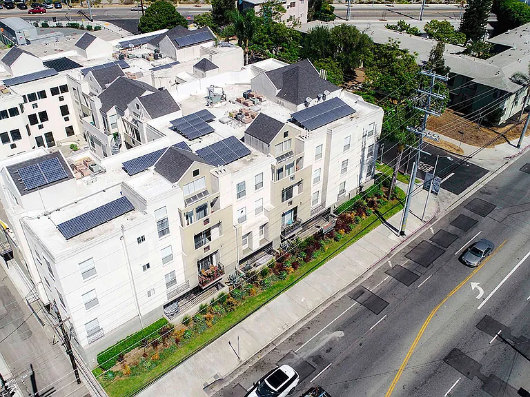 Aerial drone image off Palms Blvd showing solar panels and white roof.