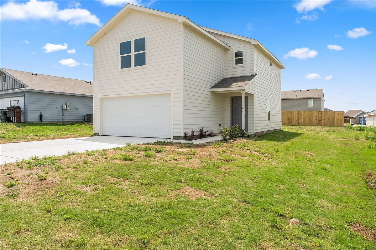 Two-story residence featuring light-colored horizontal siding, an attached garage, and a covered entryway - 303 Victory Dr