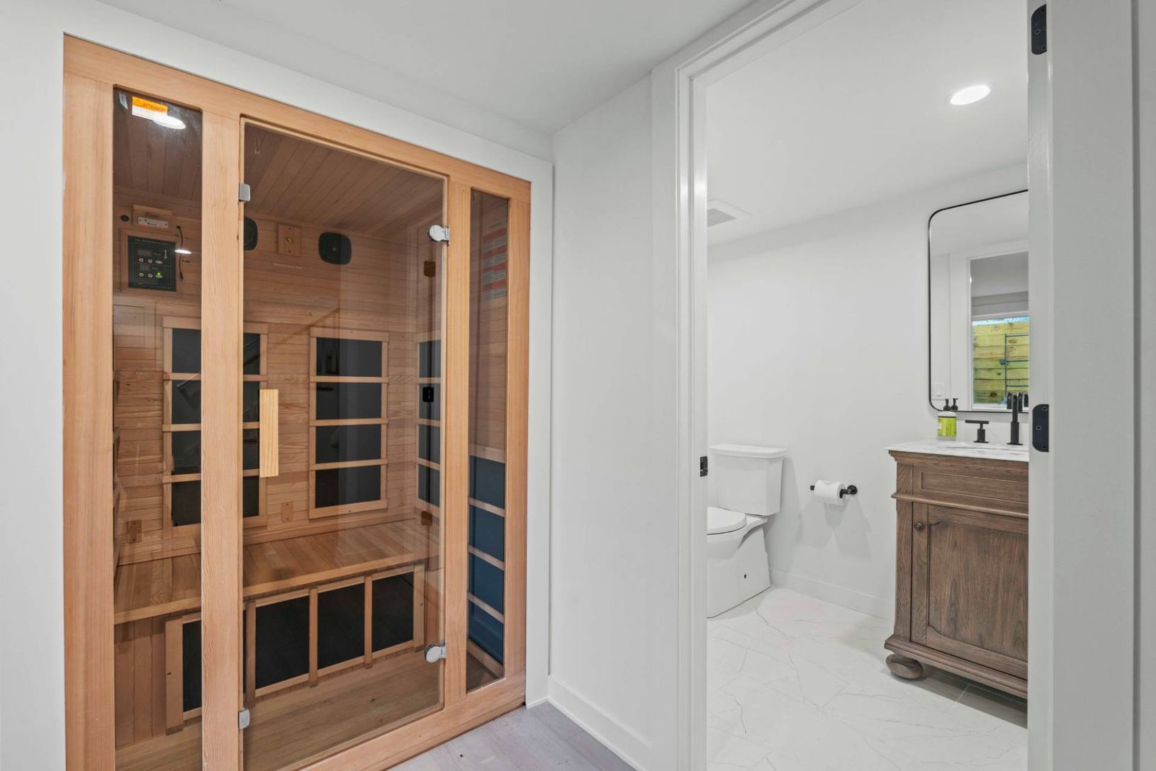 Resort Sauna ready and waiting with adjacent fullbath marble tile flooring and recessed lighting