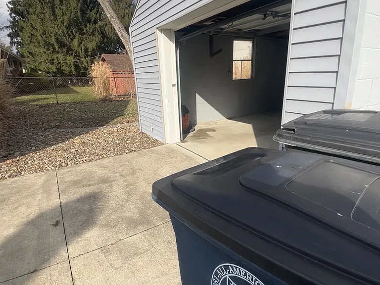 Garage exterior with manual lift door.