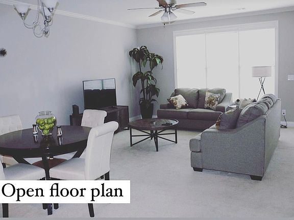 Open floor plan with kitchen, powder room, and living room leading to deck.