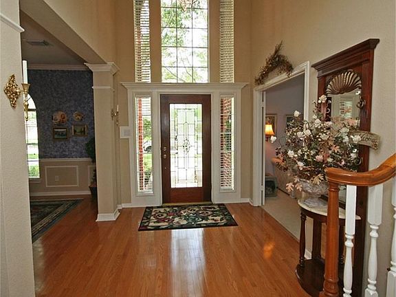 The large window above the front door accents the two story ceiling in this entry. Columns with crow