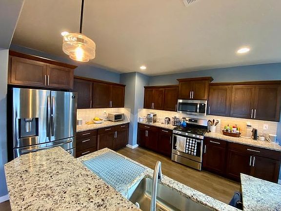 The kitchen is equipped with stainless steel appliances, plenty of tableware, and other amenities like a toaster oven, French press, and more.