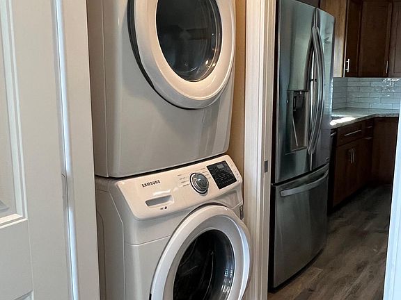 Full-size stackable washer and dryer in a separate room between kitchen and garage...opposite the washer and dryer is a small desk/workspace and cabinets