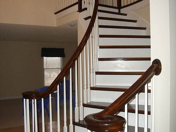 Elegant curved staircase to second floor from foyer.