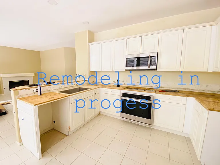 Current remodeling in progress with quartz countertops, new stainless steel appliances, breakfast counter space, farmhouse stainless steel sink and upgraded fixtures