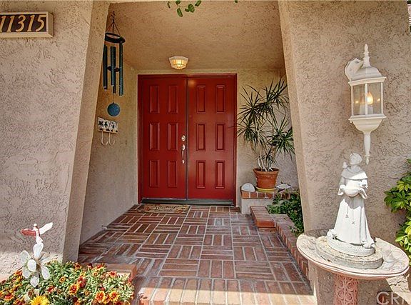 Elegant Portico with custom brick leading to Burgandy Double Doors entrance.