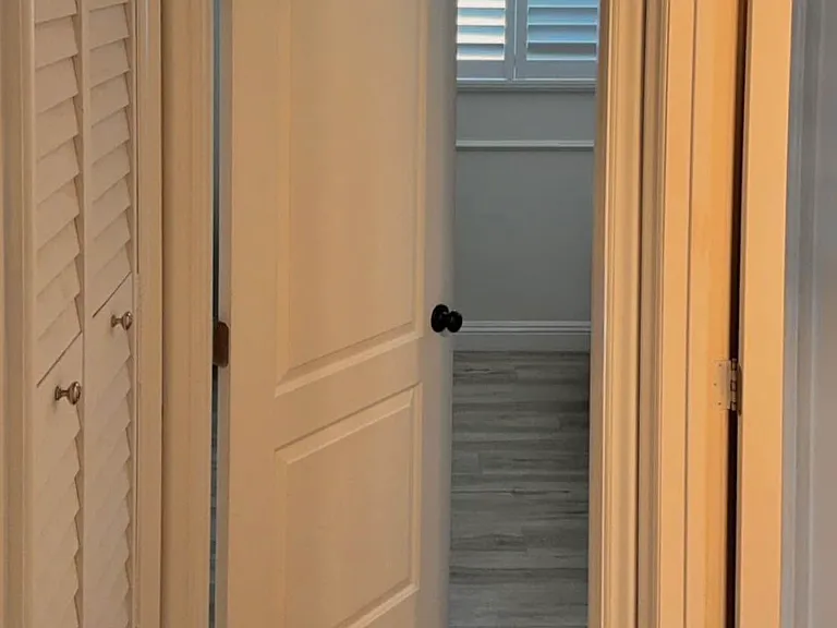Louvered doors over air-conditioning closet for an upgraded look. Bathroom hallway to second bedroom.