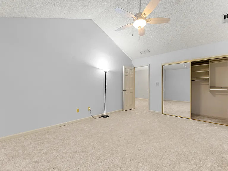 Second bedroom upstairs, open door towards the living room, and a closet with mirrored doors. This room has two large vinyl windows installed in 2018, overlooking a beautiful yard and pine trees