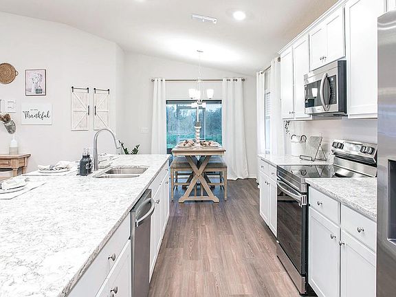 Open kitchen with counter-height island and your choice of finishes - Parker ll home plan by Highlan