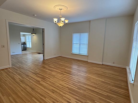 Massive living room with original hardwood floors and tall ceilings.