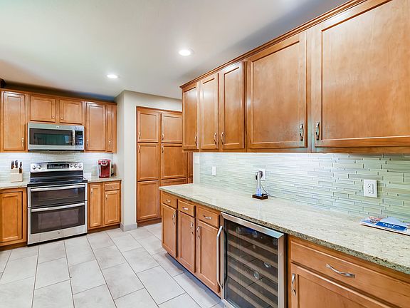 Remodeled kitchen with granite counters, upgraded appliances, ample cabinets, and modern tile and lighting.