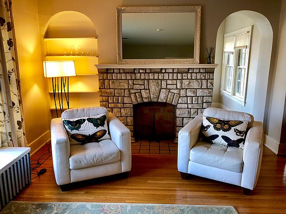 Living area with decorative fireplace and view to sunroom