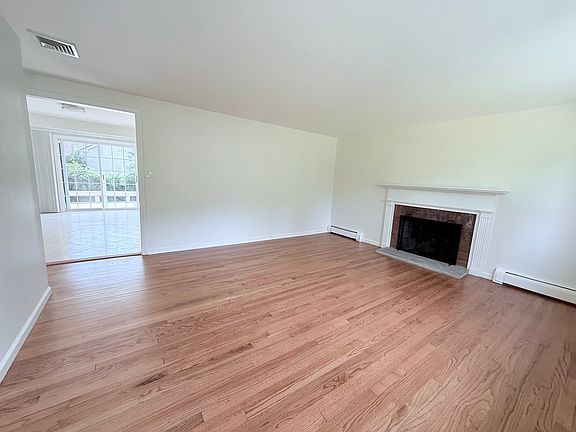 Living room opens into kitchen dining area and hallway towards bedrooms