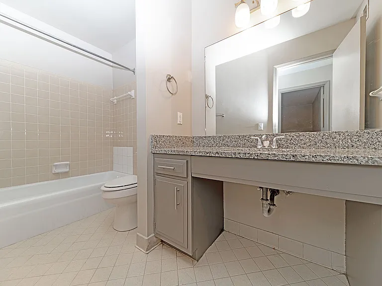 Bright bathroom with granite counters & bathtub