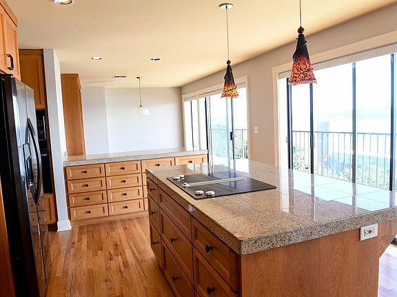 Large kitchen with granite countertopics, ceramic cook top kitchen island, new fridge, new dishwasher, oven and microwave.