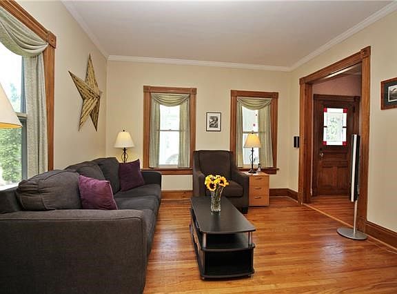 Living room with hardwood floors, and wood trim.