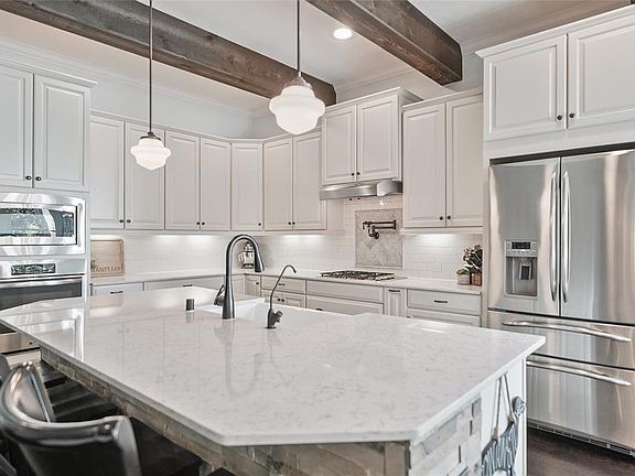 Quartz Countertops, Extensive Cabinetry (including multiple pot/pan drawers), Cedar Beams & Subway Tile Backsplash.