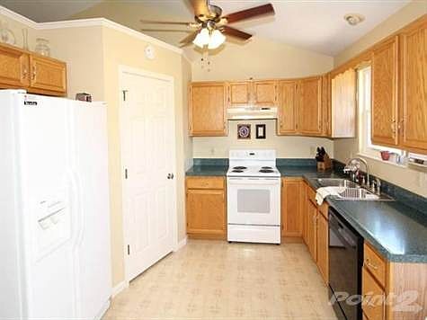 Spacious eat-in kitchen with corner pantry, generous oak cabinets, brushed nickel hardware, and ceiling fan.  Refrigerator negotiable.