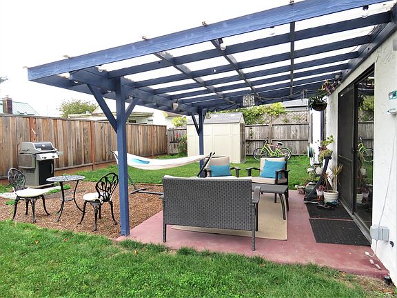 Large private back yard with covered patio and storage shed.