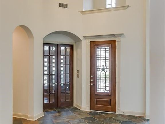 Grand entrance with soaring ceilings. French doors lead to private study.
