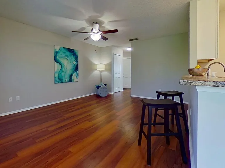Enjoy the open and airy living space in the Martinique Autograph floor plan. With beautiful wood-style flooring, a ceiling fan, and contemporary decor, this living room is perfect for relaxation and entertainment.