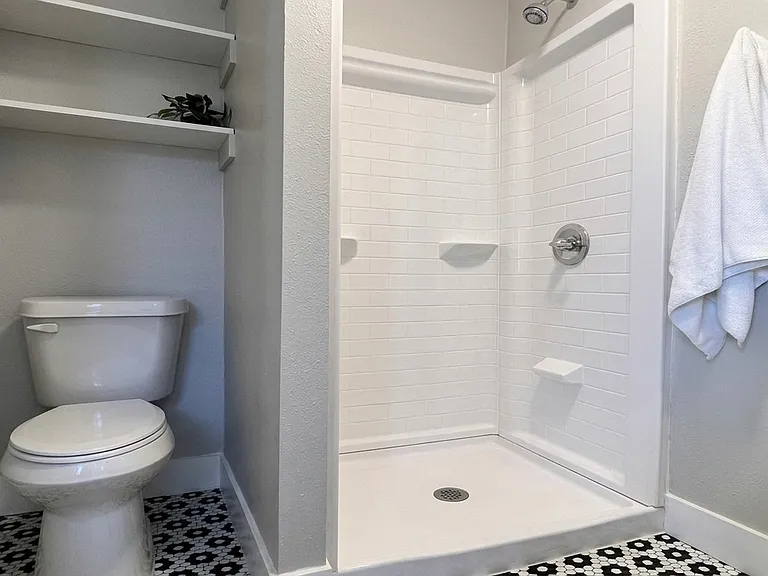 Renovated 2nd bath with new shower stall, floor and storage shelves.
