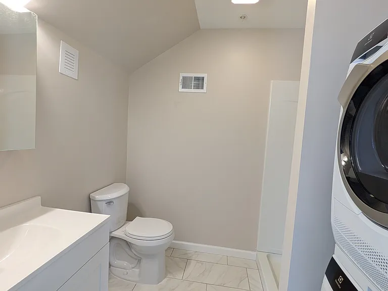 Roomy bathroom with a new shower and brand new washer/dryer