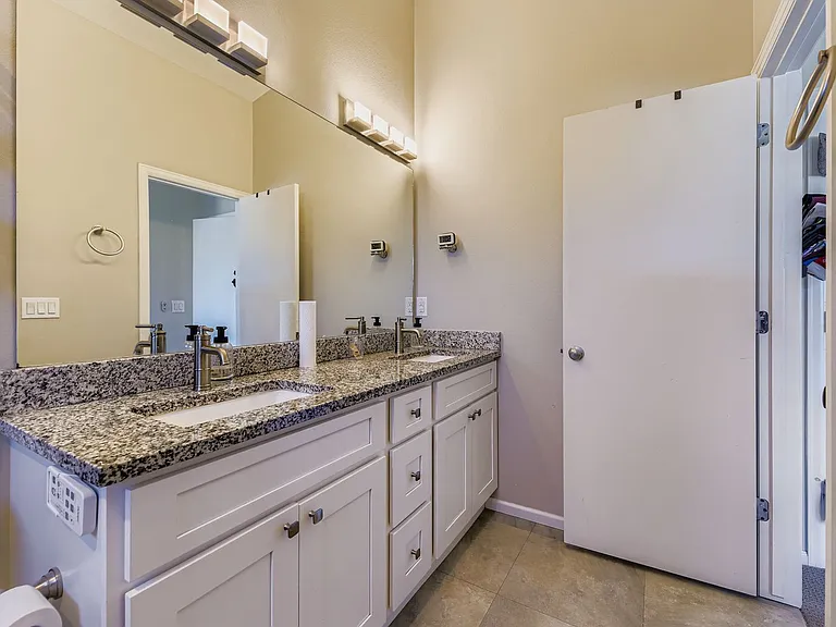 Private bathroom in primary bedroom with dual vanities