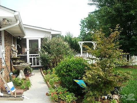 Flowers,schrubs and fountain enhance walk way to screen porch