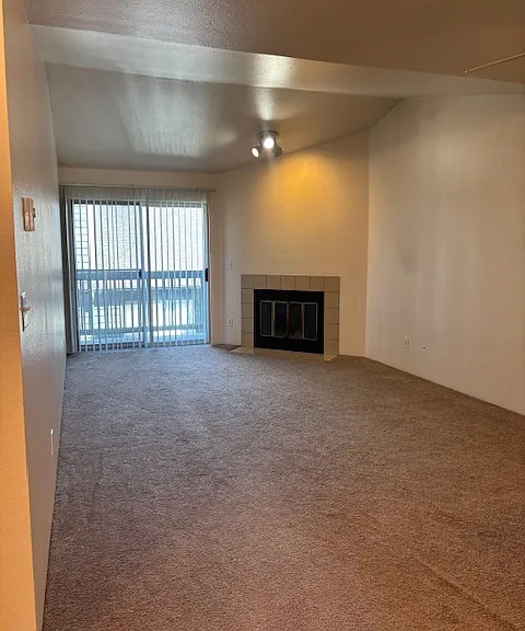 View from hallway into living room, fireplace and balcony/deck