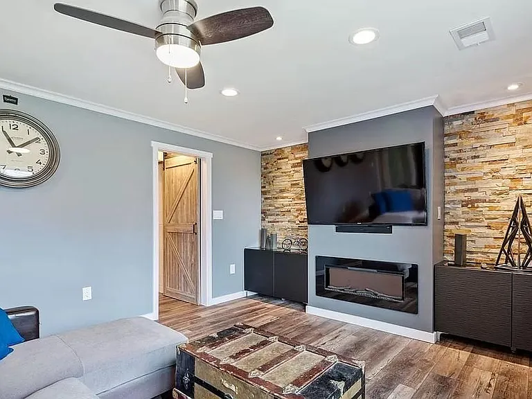 Furnished photo of large 2nd living area/family room, looking south, door on left of media center goes to laundry room