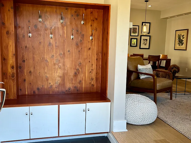 Inside the front door is a coat hanger, storage for shoes below & umbrellas above.