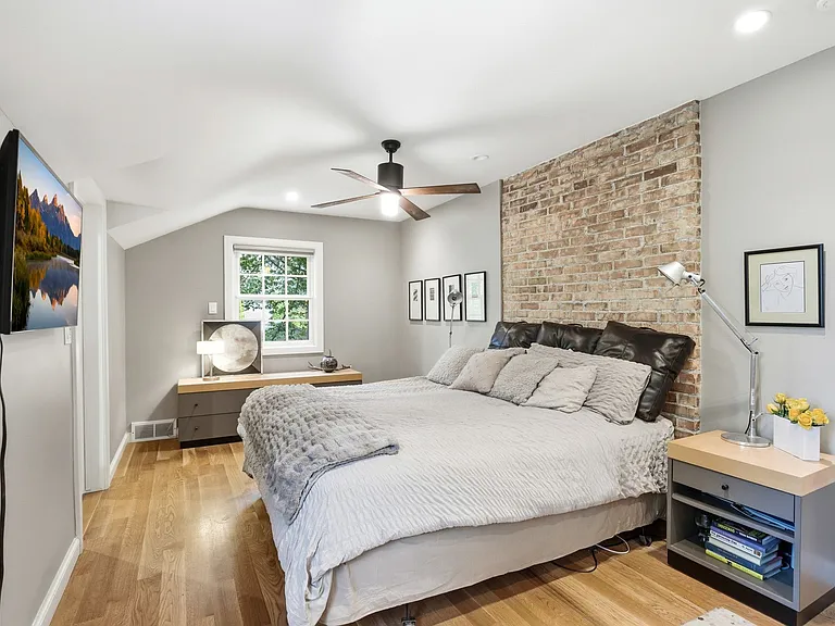 Master bedroom with exposed brick wall, ensuite bathroom and large walk-in closet.
