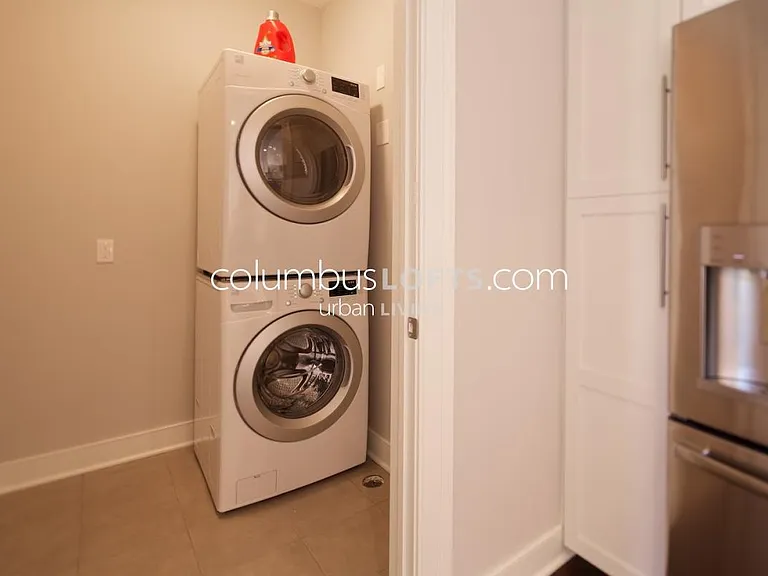main level walk-in laundry room and utility closet adjacent to kitchen has full-size stacked laundry W/D and extra storage space, too.
