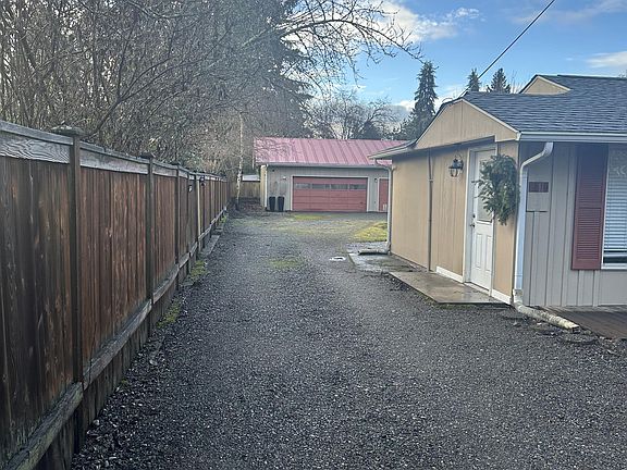 Driveway past the main house, going towards the garage, additional unit and ample parking space.