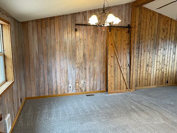Living room / dining room area. Taken from the kitchen. Sliding barn door leads to second bedroom suite.