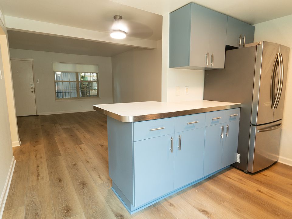 Stylish refreshed cabinets with a large stainless refrigerator.